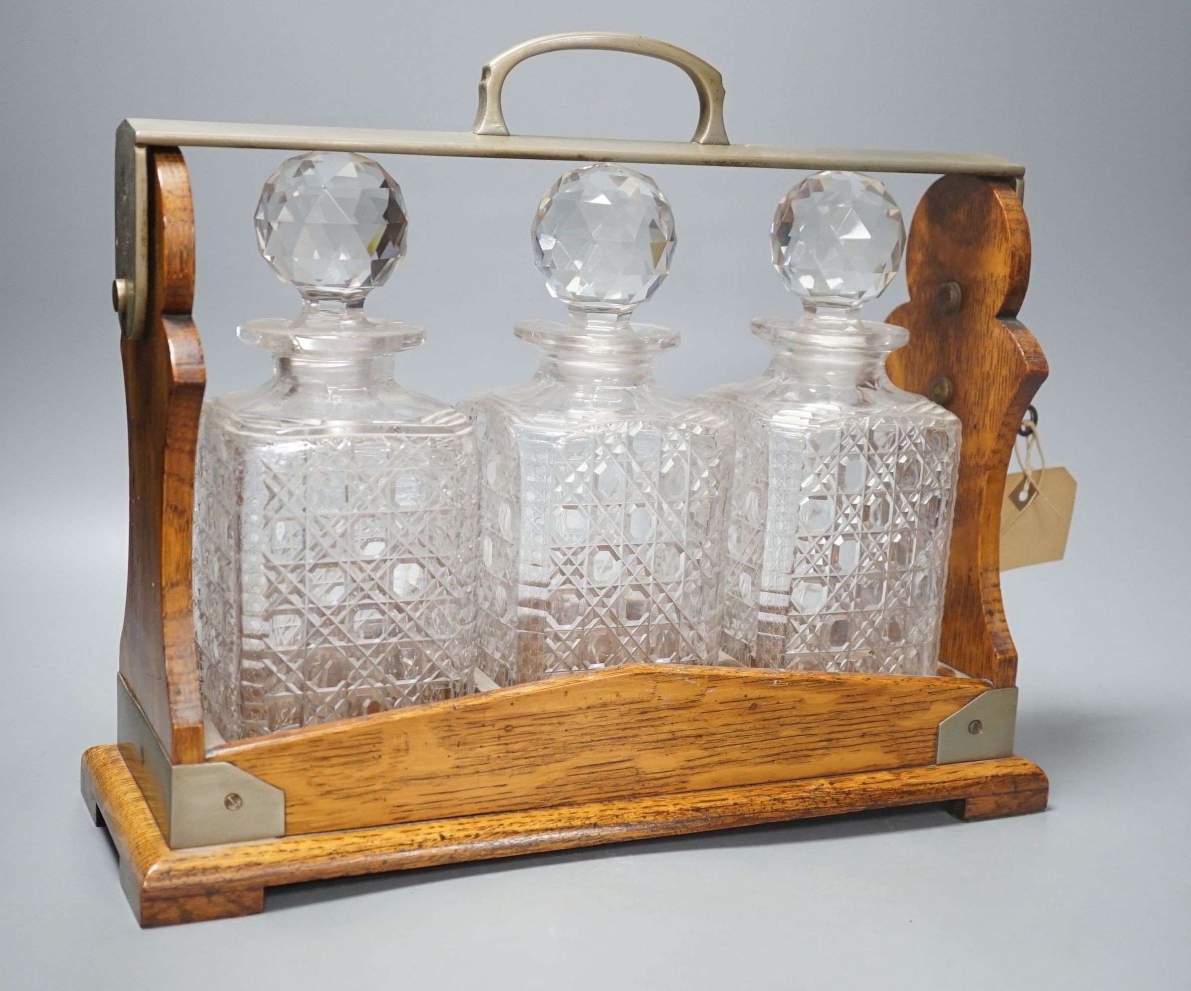 Early 20th century Betjemann's Patent oak 3 bottle tantalus, 32 cms high.